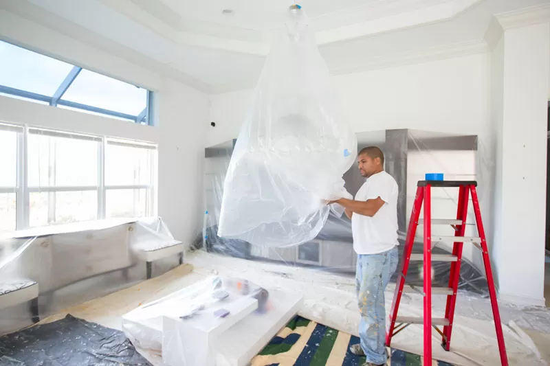 Commitment To Our Customers - Decorator using quality plastic products to protect room and furnishings